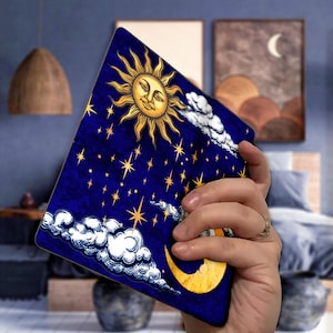 May include: A blue and gold sun and moon design with stars on a blue background. The design is on a tablet case.