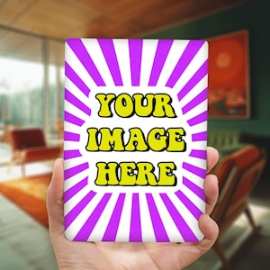 May include: A rectangular item with a white background and purple rays radiating from the center. The text "YOUR IMAGE HERE" is in yellow, outlined in black. The item is held in a hand.