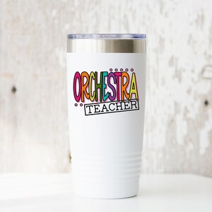 May include: White stainless steel tumbler with a colorful "ORCHESTRA TEACHER" design.