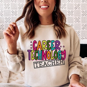 May include: A light beige sweatshirt with the text "CAREER TECHNOLOGY TEACHER" in colorful, outlined letters.