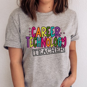 May include: Gray t-shirt with the text "Career Technology Teacher" in colorful letters.