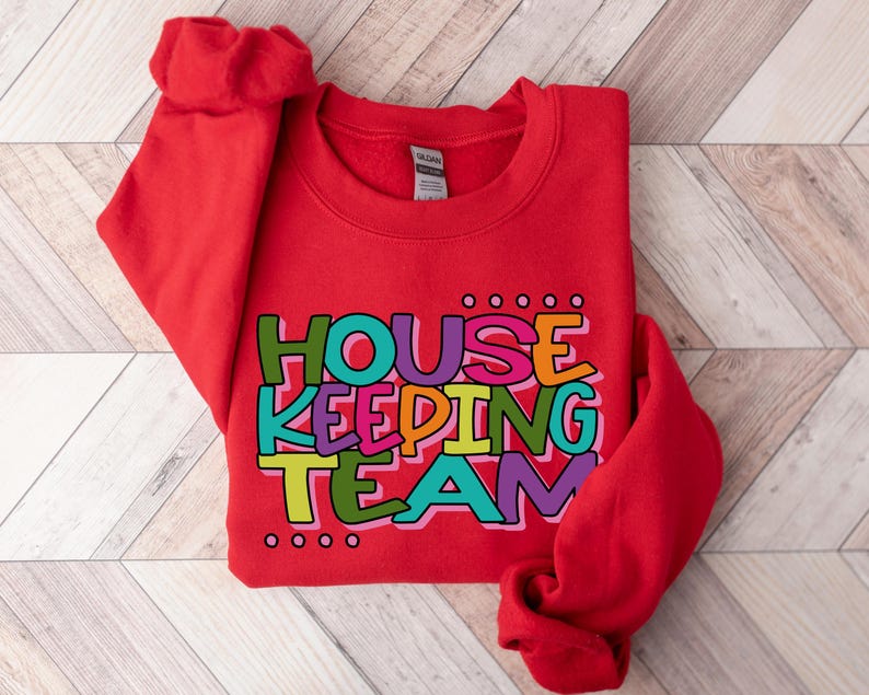 May include: Red sweatshirt with the text "HOUSE KEEPING TEAM" in colourful letters.