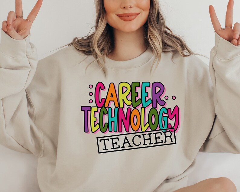 May include: A beige sweatshirt with the text "CAREER TECHNOLOGY TEACHER" in colorful, outlined letters.