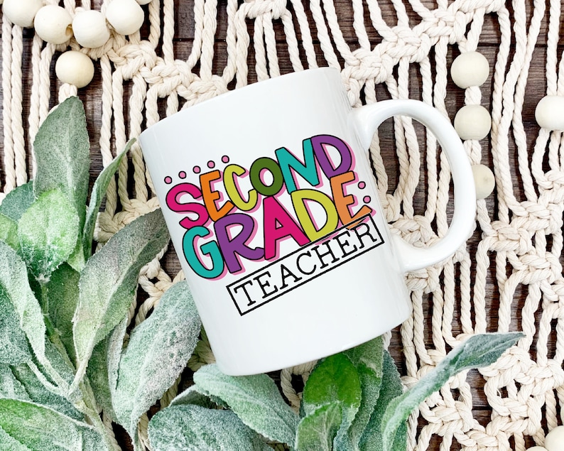 May include: White ceramic coffee mug with a colorful design that says "Second Grade Teacher".