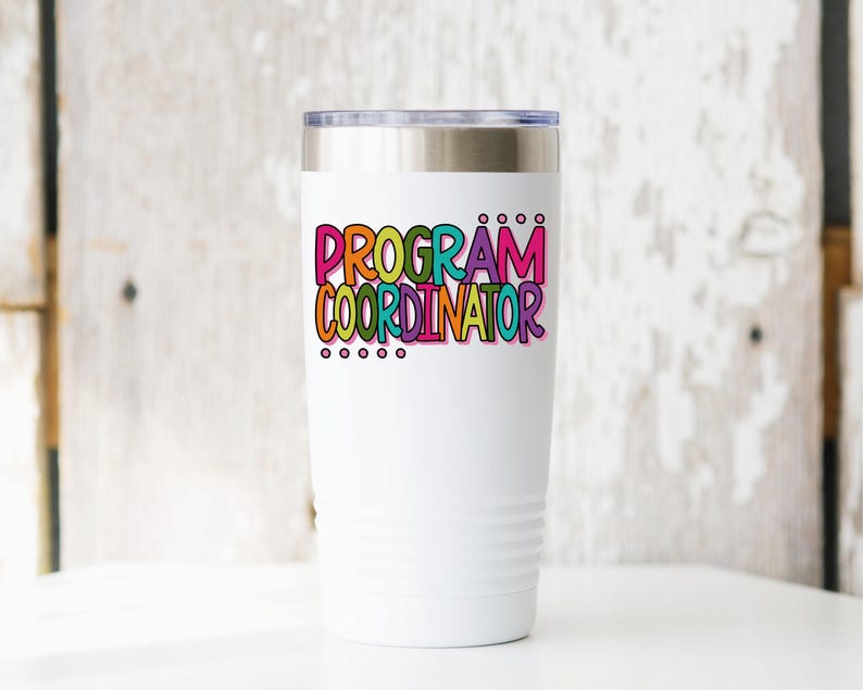 May include: A white insulated tumbler with a silver lid. The tumbler features the words "PROGRAM COORDINATOR" in colorful bubble letters. Below the text are five small black dots. The tumbler is designed to keep beverages hot or cold.