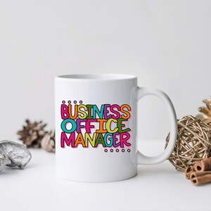 以下が含まれることがあります： 白いセラミック製のマグカップで、カラフルなデザインが施され、「Business Office Manager」と書かれています。