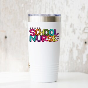 May include: White stainless steel tumbler with a colorful graphic that says "SCHOOL NURSE:"