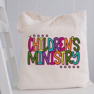 May include: A white canvas tote bag with the words "CHILDREN'S MINISTRY" printed in colorful letters.