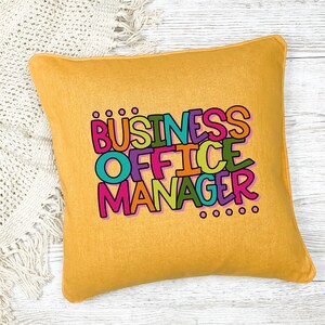 以下が含まれることがあります： カラフルな輪郭のある文字で「BUSINESS OFFICE MANAGER」と書かれた黄色のクッション