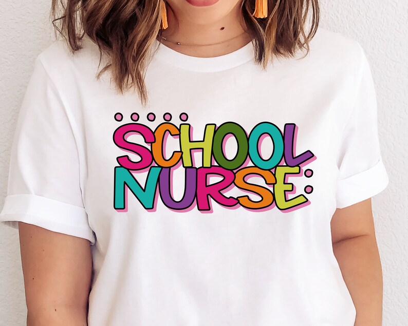 May include: White t-shirt with the text "SCHOOL NURSE" in colorful, outlined letters.