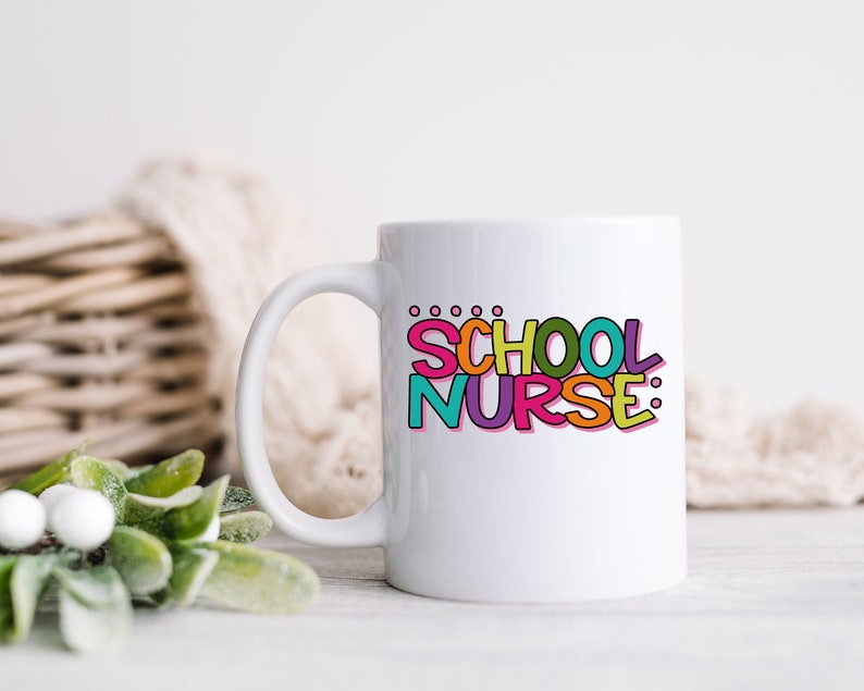 May include: White ceramic mug with a colorful graphic that says "SCHOOL NURSE:" in a playful font.
