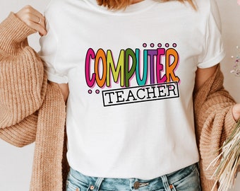 Puede incluir: Camiseta blanca con el texto "COMPUTER TEACHER" en letras de colores y contorneadas. El texto está en un estilo divertido y dibujado a mano.