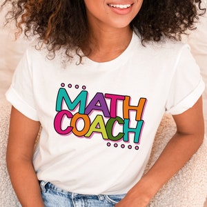 May include: White t-shirt with a colorful graphic that says "MATH COACH" in a playful font.