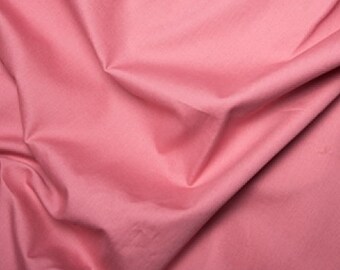 Peut inclure: Un gros plan sur un tissu doux et rose à la texture lisse. Le tissu est plié et drapé, créant un sentiment de mouvement et de fluidité.