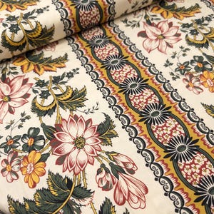 May include: White fabric with a repeating pattern of red, yellow, and green floral designs. The fabric has a border of gold, red, and black geometric shapes.
