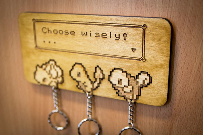 May include: Wooden key holder with a pixelated image of three Pokemon characters and the text "Choose wisely!"