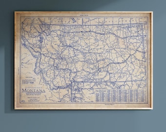 May include: A framed vintage road map of Montana, featuring blue lines on a tan background. The map includes the text "Clarion's Road Map of Montana" and is encased in a light brown wooden frame. The map shows roads and other geographical details.