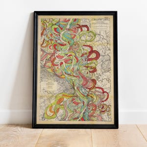 Puede incluir: Una impresión enmarcada de un mapa antiguo con un marco negro. El mapa presenta líneas sinuosas y coloridas en rojo, amarillo, verde y azul, sobre un fondo beige. El mapa está detallado con varias líneas y texto, creando una estética visualmente rica e histórica.