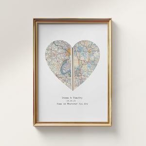 May include: A framed print featuring a heart-shaped map design. The map is split into two halves, with a gold frame. The text reads "Diana & Timothy 03.04.25 Home is Wherever You Are."