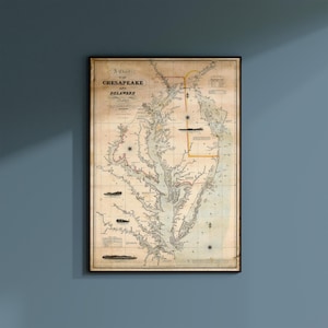 May include: Framed vintage map titled "A Chart of Chesapeake and Delaware Bays." The map features detailed coastlines, waterways, and text. The map is framed in a black border and mounted on a blue wall.