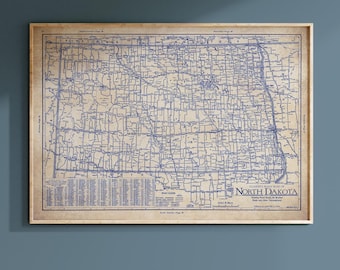 May include: A framed vintage road map of North Dakota, featuring a detailed blue line drawing of roads and towns on a tan background. The map includes the text "North Dakota" and "Road Legend".