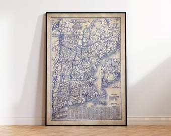 Könnte beinhalten: Gerahmte Vintage-Karte der Neuenglandstaaten mit detaillierter blauer Strichzeichnung auf beigem Hintergrund. Die Karte befindet sich in einem schwarzen Rahmen und lehnt an einer weißen Wand und einem Holzboden.