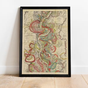 May include: Framed vintage map print featuring a detailed, colorful depiction of a river system. The map showcases winding waterways in shades of red, green, and yellow against a beige background. The black frame adds a classic touch to this decorative wall art.