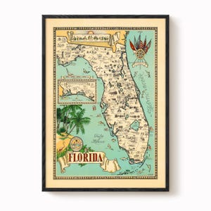 May include: Framed vintage map of Florida, featuring detailed illustrations of the state's geography and landmarks. The map is in a black frame, with a cream-colored background and a teal-colored ocean. The word "Florida" is displayed in a banner.