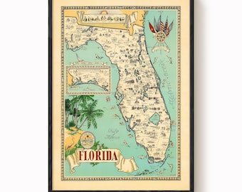 May include: Framed vintage map of Florida, featuring detailed illustrations of the state's geography and landmarks. The map is in a black frame, with a cream-colored background and a teal-colored ocean. The word "Florida" is displayed in a banner.
