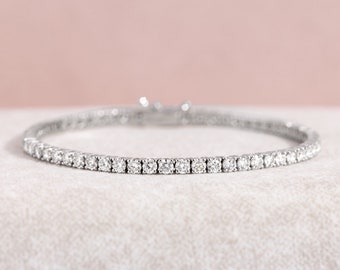 May include: A delicate silver bracelet with a row of small, sparkling diamonds.