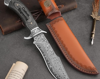 May include: A hunting knife with a patterned blade and a dark wooden handle. The knife has a silver bolster and is accompanied by a brown leather sheath. The handle has the words "Custom Engraving".