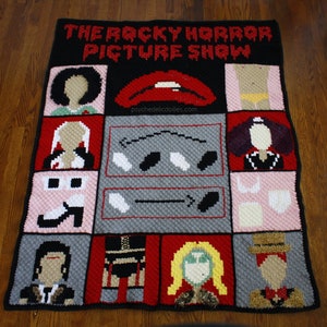 May include: A crochet blanket featuring characters from the movie "The Rocky Horror Picture Show". The blanket is made with different colored yarn and features a variety of characters, including Dr. Frank-N-Furter, Brad Majors, and Janet Weiss.