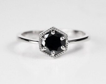 May include: A silver ring with a black hexagonal gemstone.