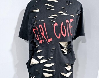以下が含まれることがあります： 前面に赤い文字で「GIRL CODE」とプリントされた、黒のダメージ加工Tシャツです。