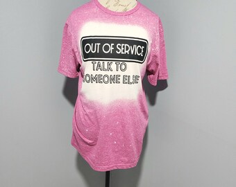 May include: Pink t-shirt with a white bleach design. The design says "Out of Service" with a black border and "Talk to Someone Else" underneath.