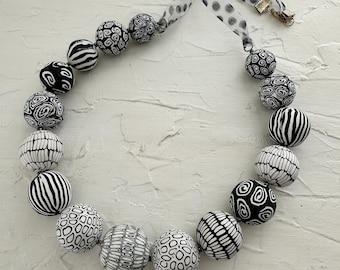 Collar con cuentas gruesas de diseño en blanco y negro.