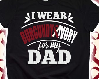 Può includere: T-shirt nero con la scritta "I Wear Burgundy & Ivory for my Dad". Il testo è in bianco e bordeaux, con un nastro bordeaux. La maglietta ha un girocollo e maniche corte.