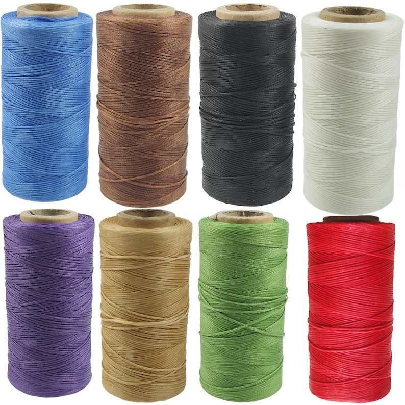 May include: Eight spools of waxed thread in a variety of colours, including blue, brown, black, white, purple, beige, green, and red. The spools are all the same size and shape, and they are arranged in two rows of four.