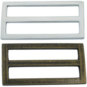 May include: Two metal belt buckle slides, one silver and one antique gold. Both have a double-slot design.
