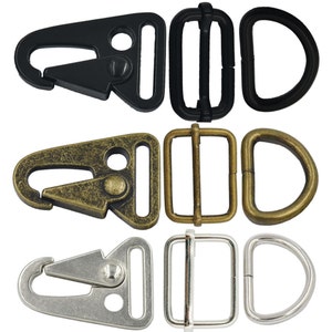 May include: Three sets of metal hardware for attaching straps or leashes. The first set is black, the second is antique gold, and the third is silver. Each set includes a trigger snap, a D-ring, and a slider buckle.