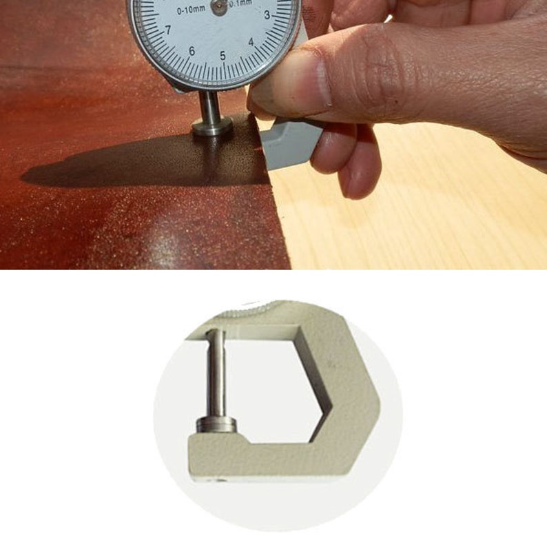 May include: A close-up of a leather thickness gauge measuring the thickness of a piece of brown leather. The gauge has a dial with markings in millimeters and a metal arm that presses against the leather.