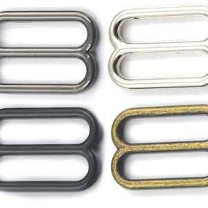 May include: Four metal slider buckles in different finishes: silver, black, nickel, and gold.