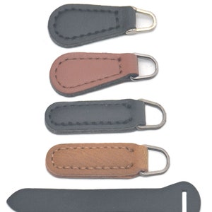 Könnte beinhalten: Fünf Leder-Reißverschluss-Zipper in Schwarz und Braun, mit einem schwarzen Lederband mit einer Metallschlaufe.