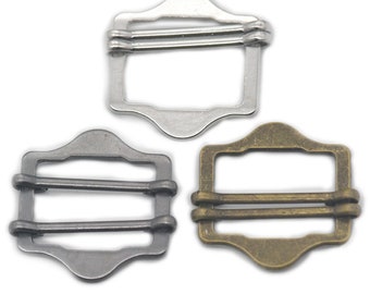 May include: Three metal slider buckles in different finishes: silver, black, and antique gold. Each buckle is rectangular with rounded corners and three parallel bars.