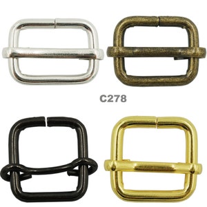May include: Four metal slider buckles in different finishes: silver, antique brass, black, and gold. The buckles are all the same size and shape, with a rectangular frame and a sliding bar in the center.