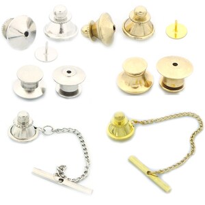 Könnte beinhalten: Sortiment an goldenen und silbernen Krawattennadeln und Krawattenklammern. Einige haben eine Kette, andere eine Nadel und wieder andere ein schlichtes Design.