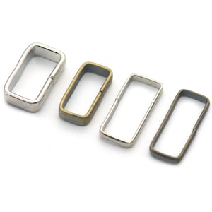 May include: Four metal belt loop buckles in different finishes: silver, brass, and two shades of antique brass.