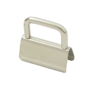 May include: Silver metal D-ring with a flat, rectangular base. The ring is open on one side and has a smooth, polished finish.