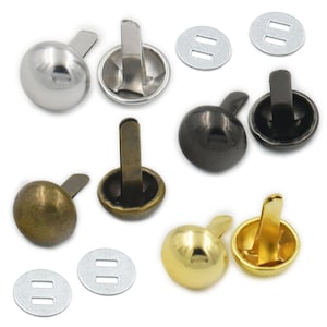 Puede incluir: Surtido de diez clavos de cabeza abovedada de metal con una variedad de acabados, incluyendo plata, negro, oro y bronce. Cada clavo tiene una base plana y una cabeza redonda. Los clavos están dispuestos en dos filas de cinco.