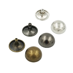 May include: Assortment of six metal dome-shaped studs in silver, black, and brass finishes. The studs have a flat base and a raised dome top.